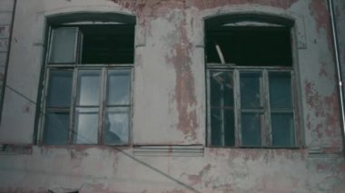 İçler acısı durumdaki çok eski bir ev. Kırılmış ve tahrip edilmiş pencereler