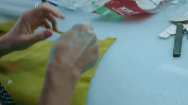 Deri atölyesinde dikiş makinesi çalışıyor. Elleri ayakkabı için deri detaylar üzerinde çalışıyor. Ayakkabı fabrikasında dikiş makinesiyle kadın eli makro çekim.