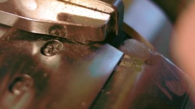 Deri atölyesinde dikiş makinesi çalışıyor. Elleri ayakkabı için deri detaylar üzerinde çalışıyor. Ayakkabı fabrikasında dikiş makinesiyle kadın eli makro çekim.