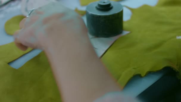 Швейная машина в кожаной мастерской в действии с руками, работающими над кожаными деталями для обуви. Макроснимок женских рук с швейной машинкой на обувной фабрике — стоковое видео