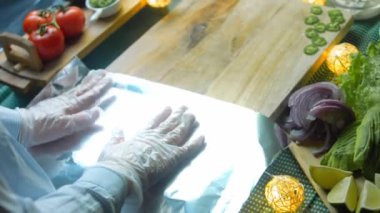 Aşçı yemek masasına alüminyum folyo koyar..