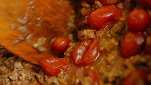 チョリソーと保存トマトの材料を木製スプーンで混ぜます — ストック動画