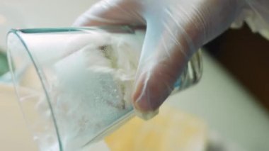 Tartı olarak un tartmak. Kadın elleri kağıt torbadan un dökerek şeffaf bir mutfak pulu kâsesine döküyor. Hamuru hazırlamaya hazırlanıyorum. Ev yapımı ekmek hamuru yapmak için gerekli malzemeler.
