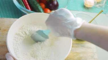 Şef tortilla malzemelerini kaşıkla karıştırıyor..