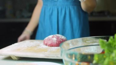 Şef unu kırmızı hamurun üzerine bastırır..