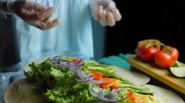 Şef burrito 'nun üzerine meyve suyu dökmek için limon ezer..