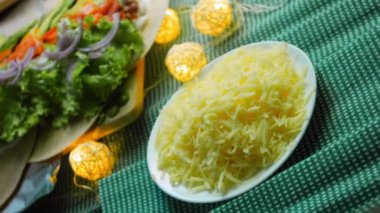 Şef burrito üzerine rendelenmiş peynir ekler..