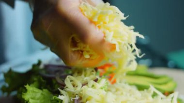 Şef burrito üzerine rendelenmiş peynir ekler..