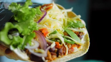 Şef büyük bir Buritto ile avokado ve sucuklu etle dans ediyor. Romantik bir ortamda çekim yapmak..