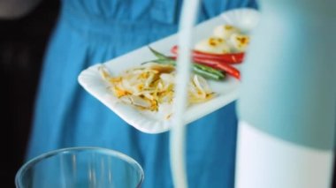 Pişmiş sebzeleri miksere dök. Kahverengi kırmızı ve yeşil soğan ve biber.