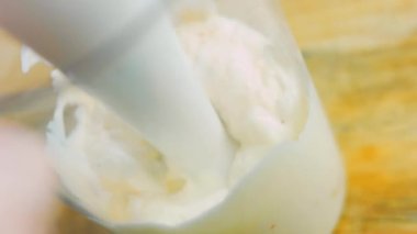 Aşçı, mayonez sosu ve blenderlı kahverengi sebzeleri yapar. Makro çekim.