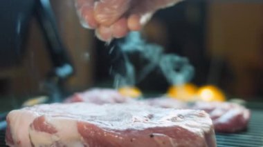 Şef ızgarada domuz eti ve biftek pişiriyor..