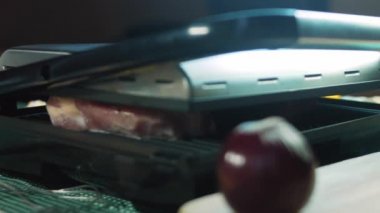 Şef ızgarada domuz eti ve biftek pişiriyor..