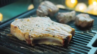 Şef ızgarada domuz eti ve biftek pişiriyor..