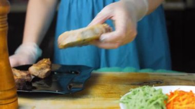 Şef taze pişmiş eti parçalara ayırır..