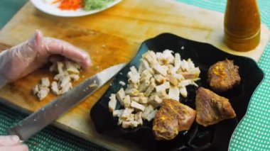 Şef taze pişmiş eti parçalara ayırır..