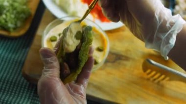 Şef taco hazırlıyor. Sebzeli mayonez sosu ekle..