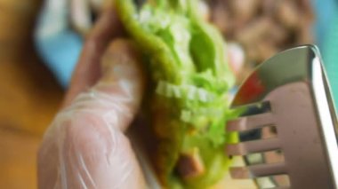 Şef taco hazırlıyor. Doğranmış taze salata ekle..
