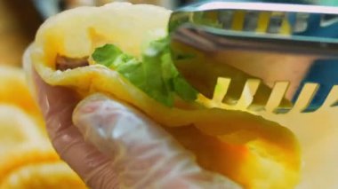 Şef taco hazırlıyor. Doğranmış taze salata ekle..