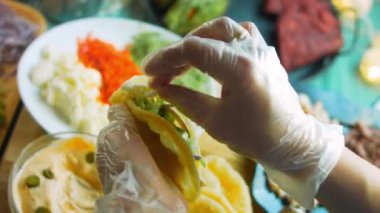 Şef taco hazırlıyor. Mozzarella peyniri ekle.