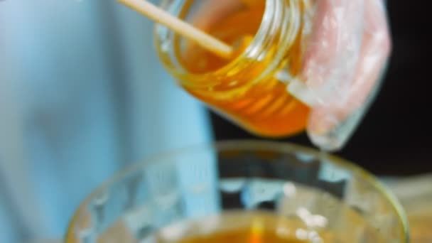 厨师把蜂蜜倒进透明的碗里 用木勺做蜂蜜 宏观射击 — 图库视频影像