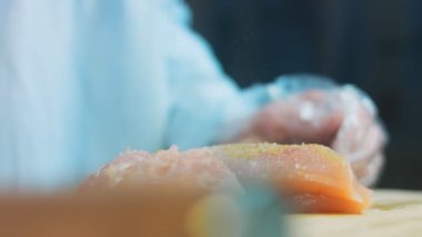 Şef tavuğa baharat koyar. Karabiber ekle.