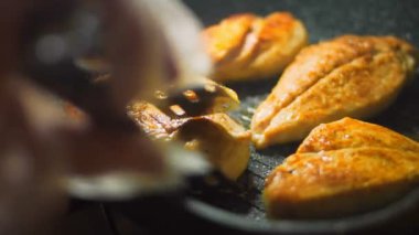 Şef ızgarada pişmiş tavuğu yemek maşasıyla pişiriyor..