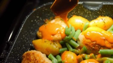 Bal Hardallı Tavuk ve VEGETable tarifi. Pişmiş et ve yeni patatesler tavada. Tavuğun üstüne hardallı bal sosu koy..