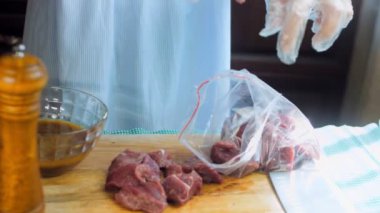 Şef salamura için eti yemek paketine koyar..