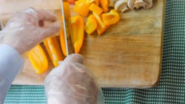 Şef sarı ve tatlı biberleri profesyonel bir bıçakla keser..