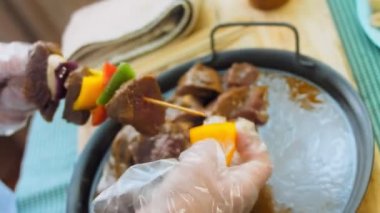 Izgarada sebzeli marine edilmiş sığır kebabı. Şef köfteleri ve sebzeleri deliyor. Sarı kilden ekle. Makro çekim.