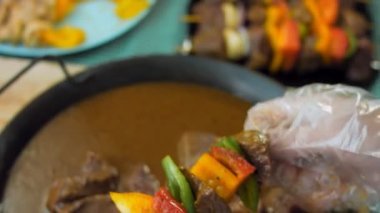 Izgarada sebzeli marine edilmiş sığır kebabı. Aşçı köfteyi tabağa koyar..