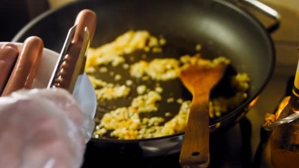 厨师在煎锅里用食物钳煎肉香肠 — 图库视频影像