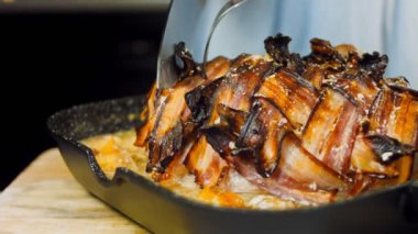 Domuz pastırması sarılı domuz filetosu. Elma suyu tarifinde kızartılmış. Şef domuz eti keser..