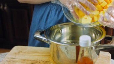 Aşçı patatesleri kaynatmak için tencereye koyar..