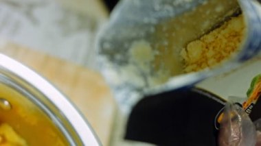 Şef patates püresinin üzerine parmesan peyniri koyar..