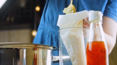 Şef, formlar için patates püresini yemek poşetine koyar..