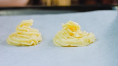 Şef bir yemek poşeti kullanarak patates kurabiyesi yapar. Patates kurabiyeleri kanonik tarif Brie, parmesan peyniri ve ağır krema