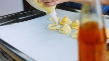 Şef bir yemek poşeti kullanarak patates kurabiyesi yapar. Patates kurabiyeleri kanonik tarif Brie, parmesan peyniri ve ağır krema