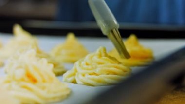 Şef patates kurabiyelerini fırçayla yağlıyor. Patates kurabiyeleri kanonik tarif Brie, parmesan peyniri ve ağır krema