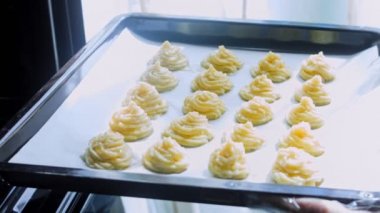 Patates kurabiyeleri kanonik peynir, parmesan peyniri ve ağır krema. Şef fırında patates kurabiyesi pişirir. Aniden rüzgardan kopan güneş ışınları dalları salladı..