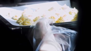 Patates kurabiyeleri kanonik peynir, parmesan peyniri ve ağır krema. Şef fırında patates kurabiyesi pişirir. Aniden rüzgardan kopan güneş ışınları dalları salladı..