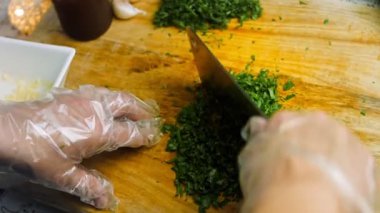 Şef maydanozu profesyonel bir bıçakla öğütür..