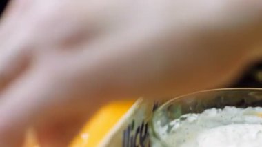 Aşçı yemek folyosunu çiftlik sosuyla kaplıyor. Makro .