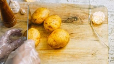 Şef dört soyulmuş patatesi keser. Kaydırıcı atışı.