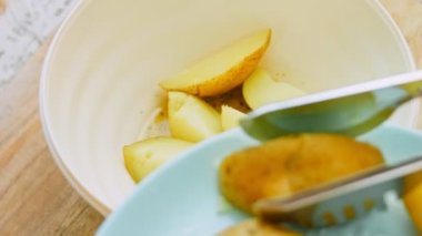 Aşçı haşlanmış patatesleri maşayla birlikte bir kaseye koyar..