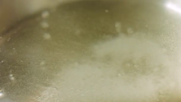 料理人は沸騰した水に塩を置きます 激しい蒸気でマクロ撮影 — ストック動画