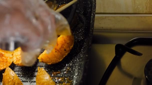 口の中で溶かしたジャガイモを焼きます 鍋にジャガイモを炒める 料理人はジャガイモを食物トングで返します マクロ撮影とスライダー撮影 — ストック動画