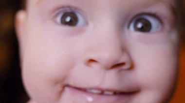 Bir yaşındaki kız gülümsüyor ve flört ediyor. Macro ağır çekimde çekim yapıyor..