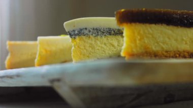 Arka arkaya dizilmiş dört çeşit cheesecake. Kaypak ve makro atış. Bir retro stil pişirme tahtası kullanılır.